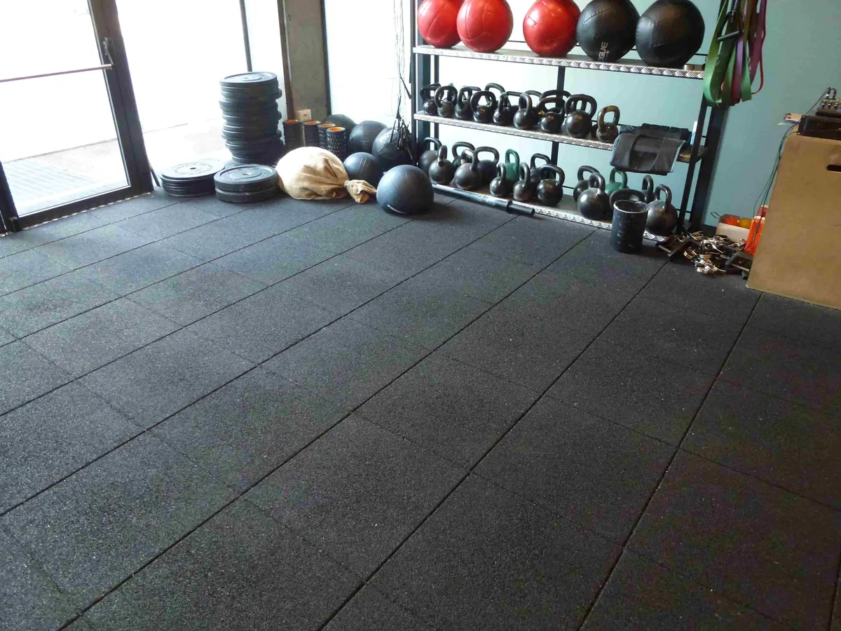 Zona de entrenamiento con kettlebells y suelo ECO-GYM de losas negras