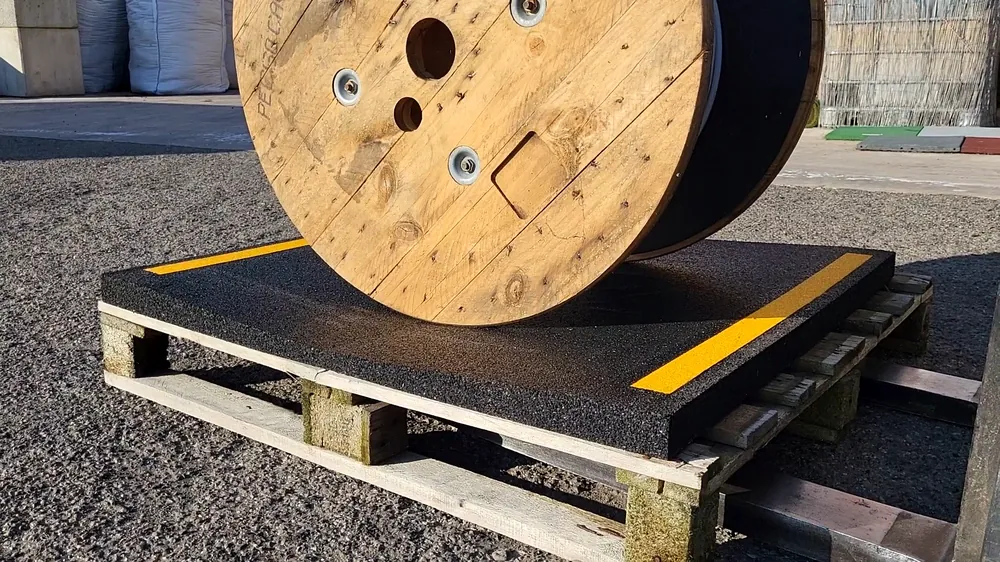 Spule, die auf einem Stabilisierungssockel vom Typ „ECO-COIL TRAP“ aus Recyclinggummi aufliegt