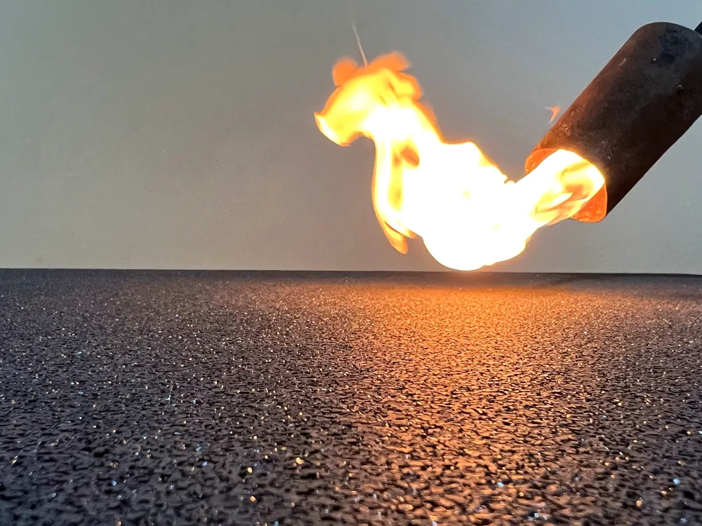 ECO-FLAME STOP GYM 4 Flamme, die auf die Oberfläche des ECO-FLAME STOP GYM-Bodenbelags angewendet wird