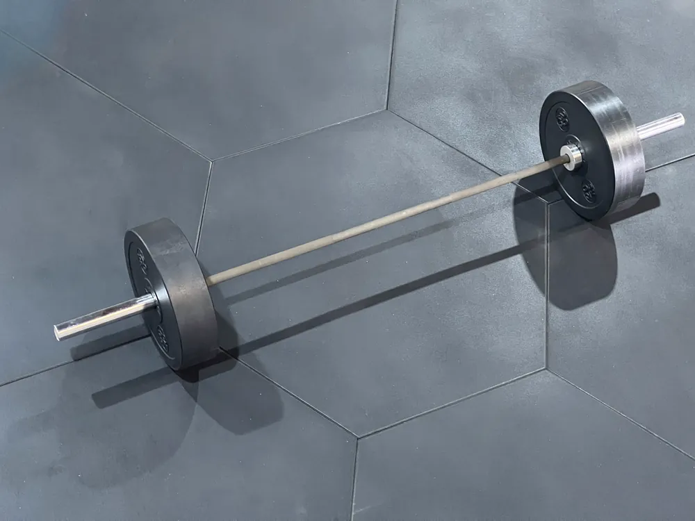 Cahier des charges pour le revêtement de sol d’une salle de sport : guide technique pour le choix 3 Disques hexagonaux ECO-GYM TOP ESA avec barre dans la zone de poids libres