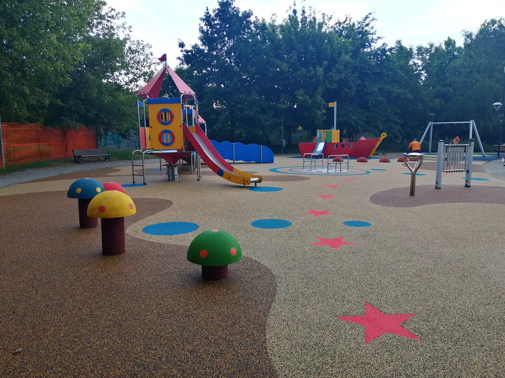 ECO-MUSHROOM 5 ECO-MUSHROOM, aufgestellt auf einem Spielplatz mit farbigem Bodenbelag